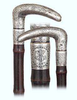 184. Silver Day Cane -Ca. 1890 -Large L-shaped silver handle with a slightly arched hand rest and pointed tip totally engraved with scrolls, floral an