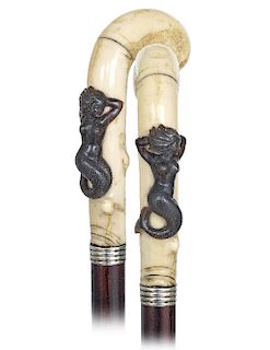 70. Walrus and Horn Mermaid Cane -Ca. 1870 -Walrus pistol grip handle with a dark horn siren applied to the stretching and knobbed vertical stem, dark