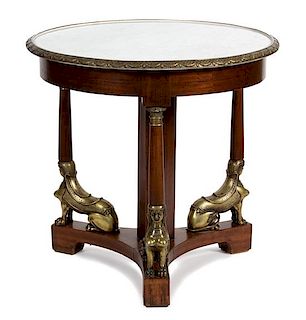 An Empire Style Gilt Metal Mounted Mahogany Center Table Height 31 x diameter of top 32 1/2 inches.