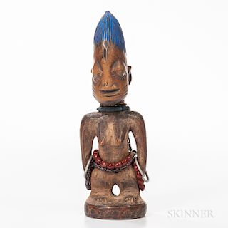 Female Yoruba Ibeji Figure, standing on a circular base, with raised feet, legs set apart with the arms detached from the body and hand