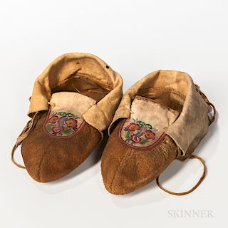 Cree Silk-embroidered Hide Moccasins, c. late 19th century, the vamp with multicolored floral designs, large cuffs and long hide laces,