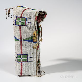 Lakota Beaded Hide Cradle, fourth quarter 19th century, lined with printed cotton and beaded with multicolored geometric designs, with
