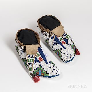 Pair of Fully Beaded Plains Moccasins, Lakota, fourth quarter 19th century, beaded sole form with multicolored geometric designs on a w