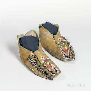 Apache Beaded Hide Man's Moccasins, early fourth quarter 19th century, with rawhide soles, heel beadwork, and stained with yellow, the