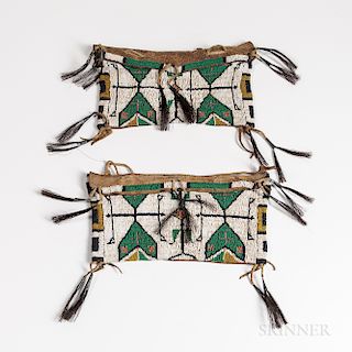 Pair of Plains Beaded Buffalo Hide Storage Bags, fourth quarter 19th century, each sinew sewn in yellow, green, black, and translucent