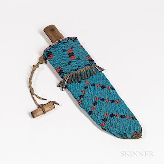 Plains Beaded Hide Knife Case, Lakota, c. 1880s, with buffalo hide liner, the front fully beaded with blue background, central tin cone