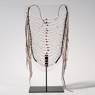 Plains Ceremonial Chest Ornament, c. 1870s, Crow, eighteen strands of white and red beads, strung with sinew and attached to two leathe