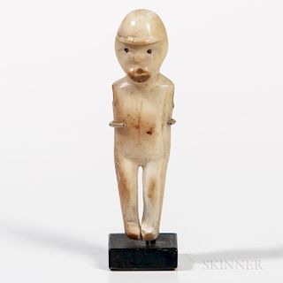 Eskimo Figure, Alaska, 19th century, eyes and mouth pierced, holes for the arms (arms missing), ht. 2 1/2 in.Provenance: Dr. John Schae