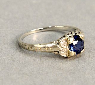 18 karat white gold ring with blue stone, possibly sapphire.