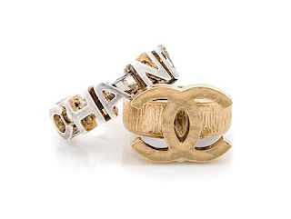A Pair of Chanel Rings, Goldtone CC size: 6 1/4; Silvertone charm size: 6 1/4.