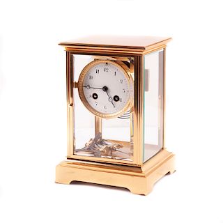 Reloj de mesa. Francia, siglo XX. Diseño de la marca Japy Freres. Caja rectangular dorada, puertas y paredes de vidrio.