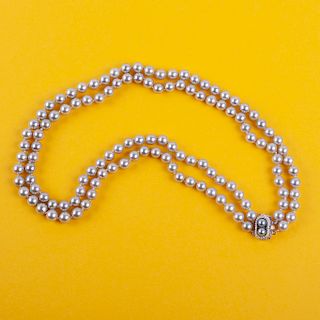 Collar de perlas con broche en metal. Con 125 Perlas cultivadas color gris. Medidas 5.0-6.0 mm aprox. c/u Peso: 55.1 g.