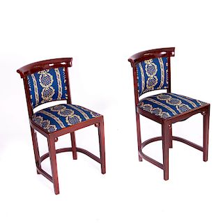 Par de sillas. Siglo XX. Elaboradas en madera tallada y barnizada de acabado brillante. Respaldo y asiento en tapicería.Piezas: 2
