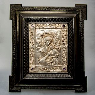 Madonna. Repujado en lámina de metal plateado. Con 4 simulantes de piedras preciosas. Enmarcado en madera tallada color negro.