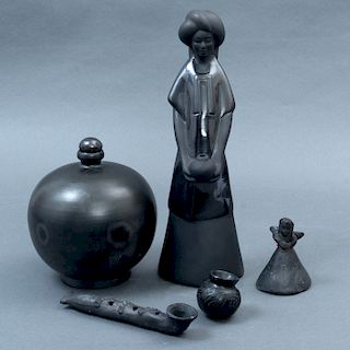 Lote de 5 art’culos decorativos. SXX. Elaborados en barro negro. Consta de: centro de mesa, mujer con turbante, flauta, campana, otro.