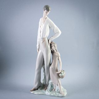 Caballero con niña. España, siglo XX. Elaborado en porcelana Rosal, acabado brillante. 39 cm de altura