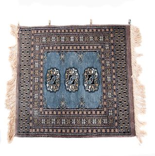 Alfombra. Pakistan, siglo XX. Estilo Bokhara. Elaborada en lana y algodón. Diseño cuadrangular. Con soporte de aluminio.