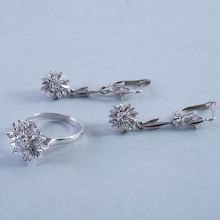Anillo y par de aretes. En plata paladio. Diseño de flor y diamantes corte brillante.