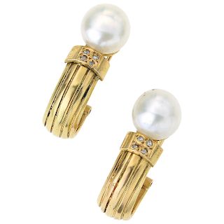 A cultured pearl and diamond 14K yellow gold pair of earrings.