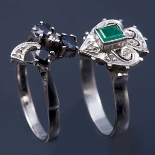 Dos anillos. Elaborados en plata paladio. Diseño calado y de listones. Decorados con una esmeralda corte cojín y tres zafiro.<...