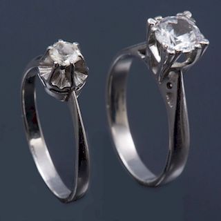 Dos anillos. Elaborados en plata paladio. Diseño en acabados lisos. Decorados con dos diamantes corte brillante. Peso: 4.7g.