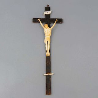 Crucifijo. Siglo XX. En talla de hueso. Con cruz de madera y cartela con inscripción "INRI".