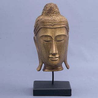 Cabeza de buda. Origen asiático. Elaborada en madera dorada. Con base de madera tallada.