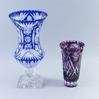 Lote de floreros. Siglo XX. Elaborados en cristal de Bohemia, color azul y morado. Diseños facetados. Con motivos vegetales. Piezas: 2