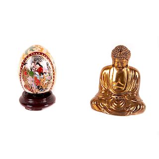 Lote de piezas decorativas. China, siglo XX. Buda Amida. Elaborado en metal dorado y huevo cerámico policromado.Pzas: 2