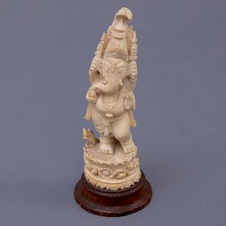 Ganesha. Origen oriental. Siglo XX. En talla de marfil. Con base de madera tallada. Ataviado con elementos mítico fantásticos.