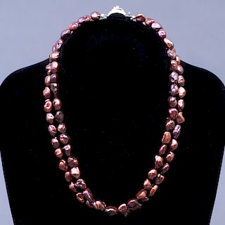 Collar de dos hilos. Elaborado con perla barrocas color café. Broche plata con 9 rubíes corte redondo.