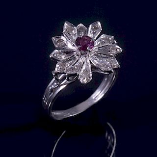 Anillo. Elaborado en plata paladio. Diseño de flor. Decorado con un rubí corte redondo y 12 acentos de diamantes. Peso: 3.5g...