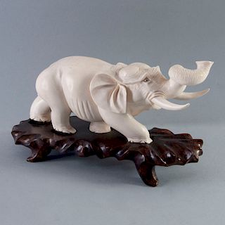 Elefante. China, siglo XX. Talla en marfil. Con base de madera.