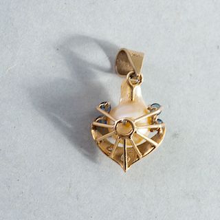 Dije. Elaborado en oro amarillo de 14 K. Decorado con perla al centro y 4 zafiros corte redondo y 5 acentos de diamante.