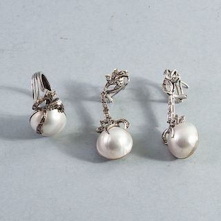 Anillo y par de aretes. Elaborados en plata paladio. Diseño largo con lacería. Decorados con tres medias perlas cultivas de 17 mm.