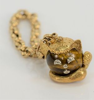 18 karat gold and tiger eye cat watch fob, having round tiger eye ball with cat face and paws of gold and white gold with double cir...