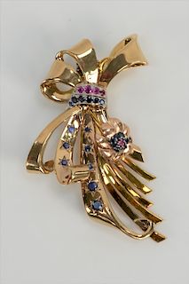 14 karat gold bow brooch with flower, mounted with blue sapphires and rubies.
height 3 inches, 31.2 grams