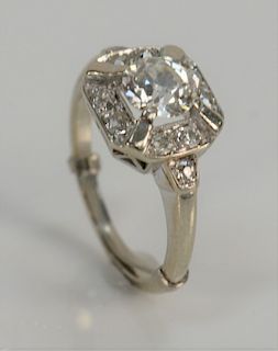 14 karat white gold and diamond ring, set with center diamond of approximately 1 ct. surrounded by eight diamonds and flanked by two...