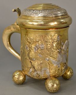Austrian silver and gilt tankard with stepped top over gilt embossed body with king and knights at castle, all set on four embossed ...
