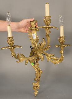 Pair of gilt rococo bronze sconces, 
having scrolling three arms with foliate and flower design, wired. 
height 28 inches, width 18 ...