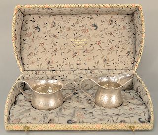 Tiffany & Co. sterling silver sugar bowl and creamer, 
both having hand hammered finish and scrolling handles, marked: Tiffany & Co....