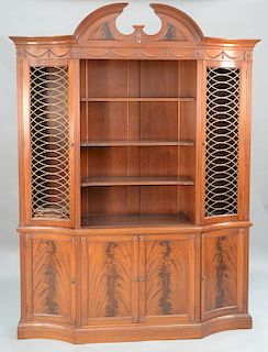Margolis mahogany breakfront in two parts, 
upper section with pediment top over swag carved panel with four shelves flanked by gril...