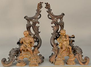 Pair of bronze figural chenets having scrolled supports with putti figures with horns (some gilt highlights remaining).  height 22...