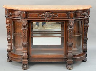 Victorian walnut curio cabinet having salmon color marble top,  over center drawer, flanked by pull-out side drawers over center gla...