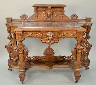 Victorian walnut and burl walnut pier table, 
carved faces, pelicans, and winged gargoyles, having two faux marble inset panels. 
he...