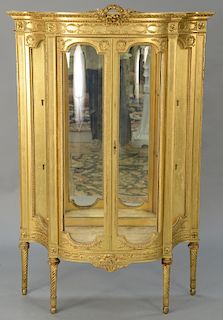 Louis XVI style gilt crystal cabinet,  with convex sides and bowed front, mirror back and glass shelves.  height 61 inches, widt...