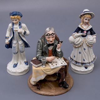 Lote de 3 figuras decorativas. Siglo XX. En porcelana. Dos con acabado brillante. Uno gres. Consta de: dama, joven y anciano.