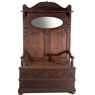 Banca/ba˙l. Francia. Siglo XX. En talla de madera de rob Con remate arquitectÛnico, espejo con luna oval biselada, asiento abatible.