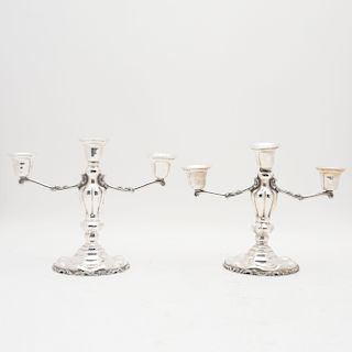 Par de candelabros. México, siglo XX. Elaborados en plata Sterling, ley 0.925. Para 3 luces, decorados con motivos vegetales. Piezas: 2