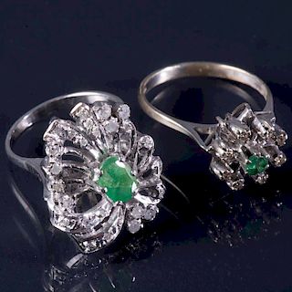 Dos anillos. Elaborados en plata paladio. Diseño floral. Decorados con dos esmeraldas corte oval y redondo. 0.60ct. 31 dia...